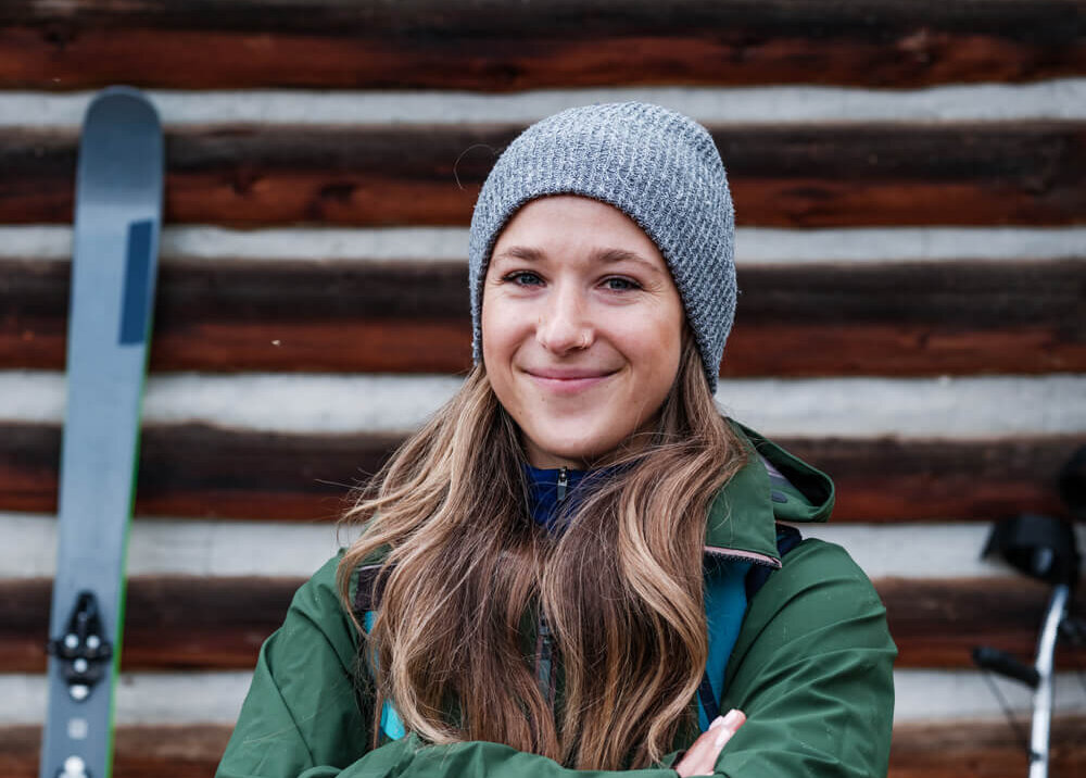 Kira Brazisnki stands in front of a cabin in a Jackson Hole winter